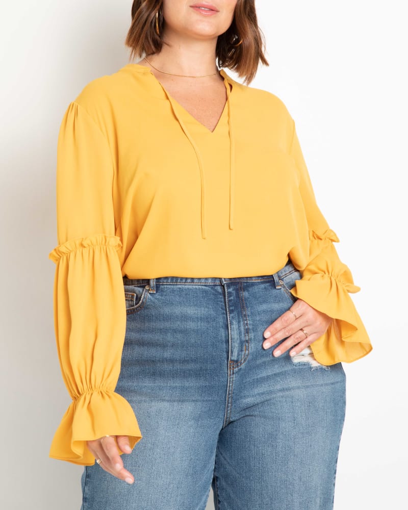 Front of a model wearing a size 14 Lane Ruffle Detail Blouse in Symphonic Sunset by ELOQUII. | dia_product_style_image_id:216990